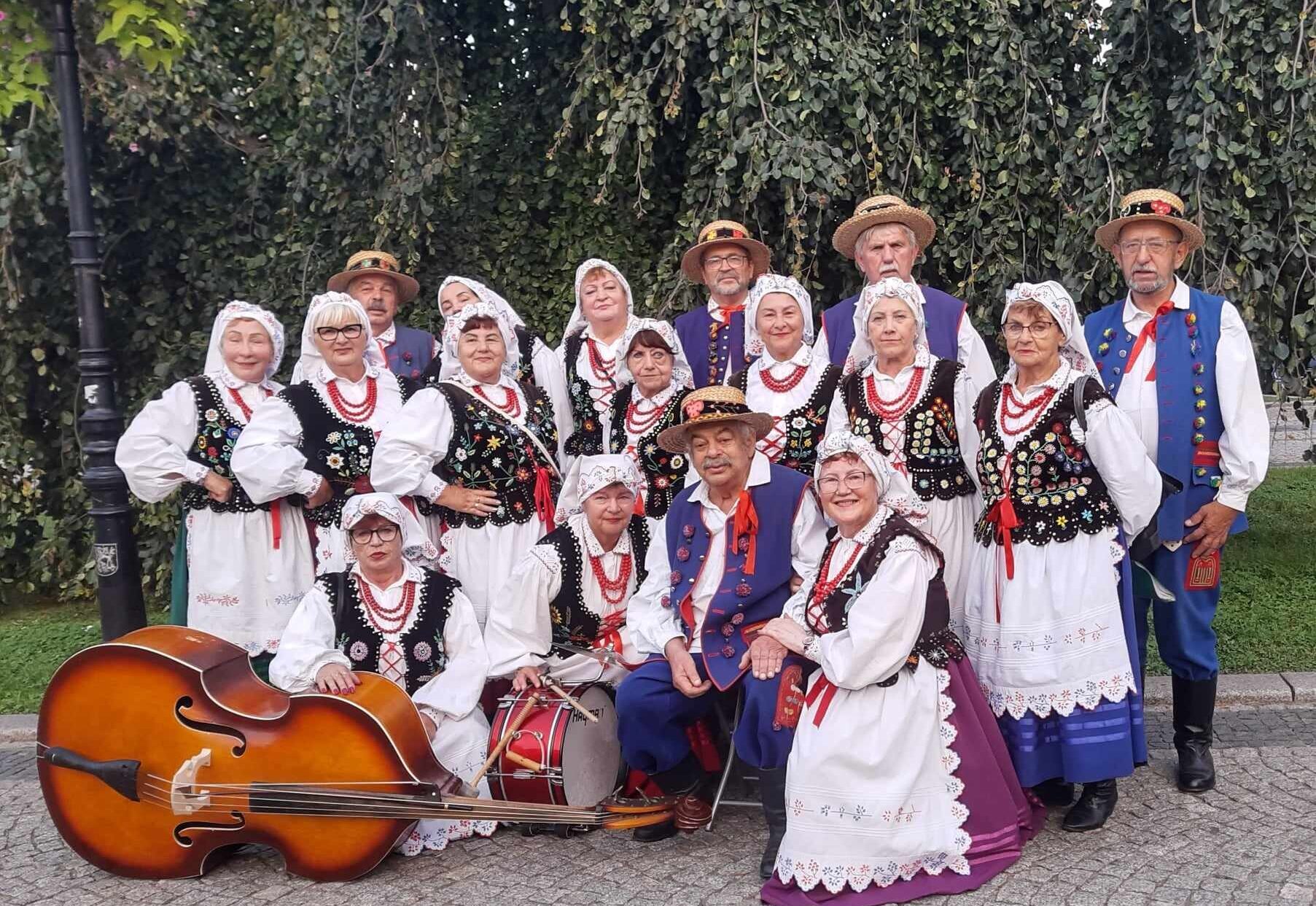 Zespół Lubin w strojach ludowych w tle drzewa