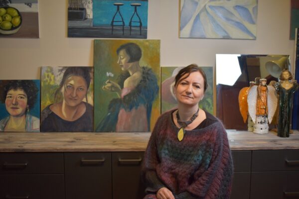 Zdjęcie Aleksandry Sieradzkiej na tle jej prac plastycznych Zdjęcie Aleksandry Sieradzkiej na tle jej prac plastycznych