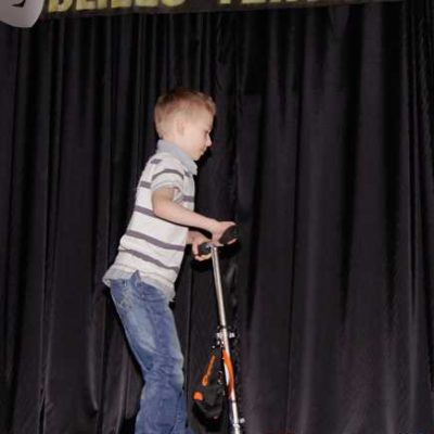 chłopiec z hulajnogą na scenie