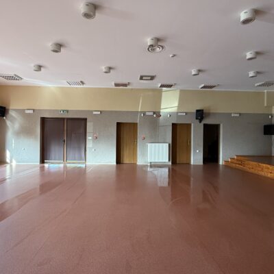 duża sala z oknami i przejścia do innych pomieszczeń