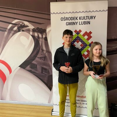 chłopiec i dziewczynka z trofeum za zajęcie 6 miejsca w turnieju bowlingowym