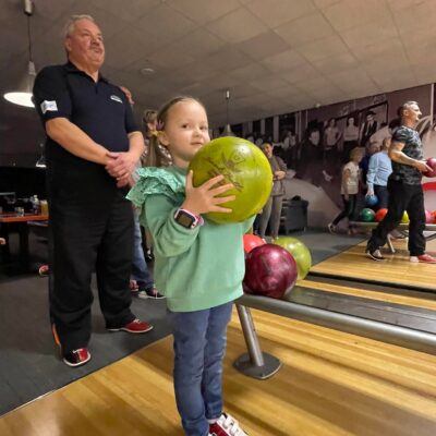 dziewczynka z kulą do bowlingu na hali bowlingowej podczas turnieju