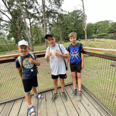 trzech chłopaców na tle małpek we wrocławskim zoo