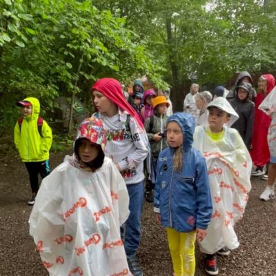 dzieci w deszczu podczas zwiedzania parku dinozaurów w zatorlandzie