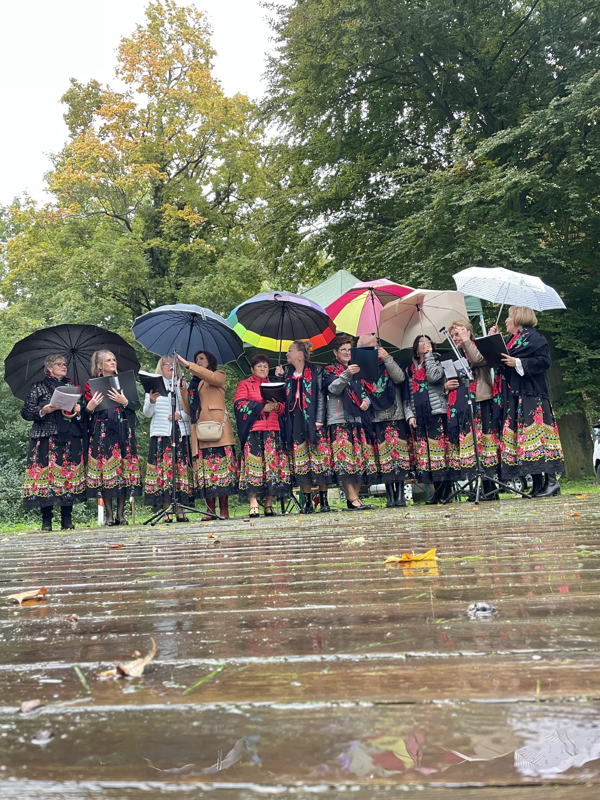 zespół osieczanki podczas występu na święcie pieczonego ziemniaka - Paie w pięknych d ługich czerwono czarnych spódnicach z parasolkami