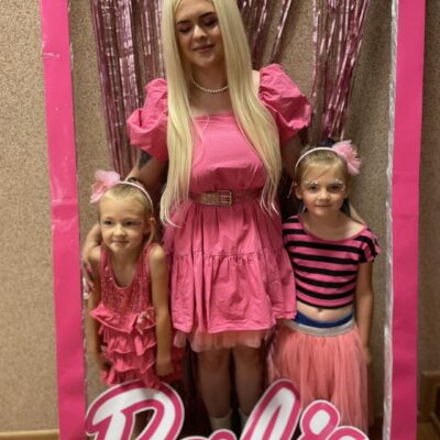 Zdjęcie przedstawia dziewczynki pozujące w "pudełku po Barbie". Wszystkie ubrane na różowo.