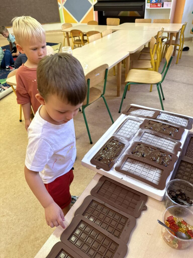 a zdjęciu widzimy dwóch chłopców, którzy dekorują swoje czekolady.