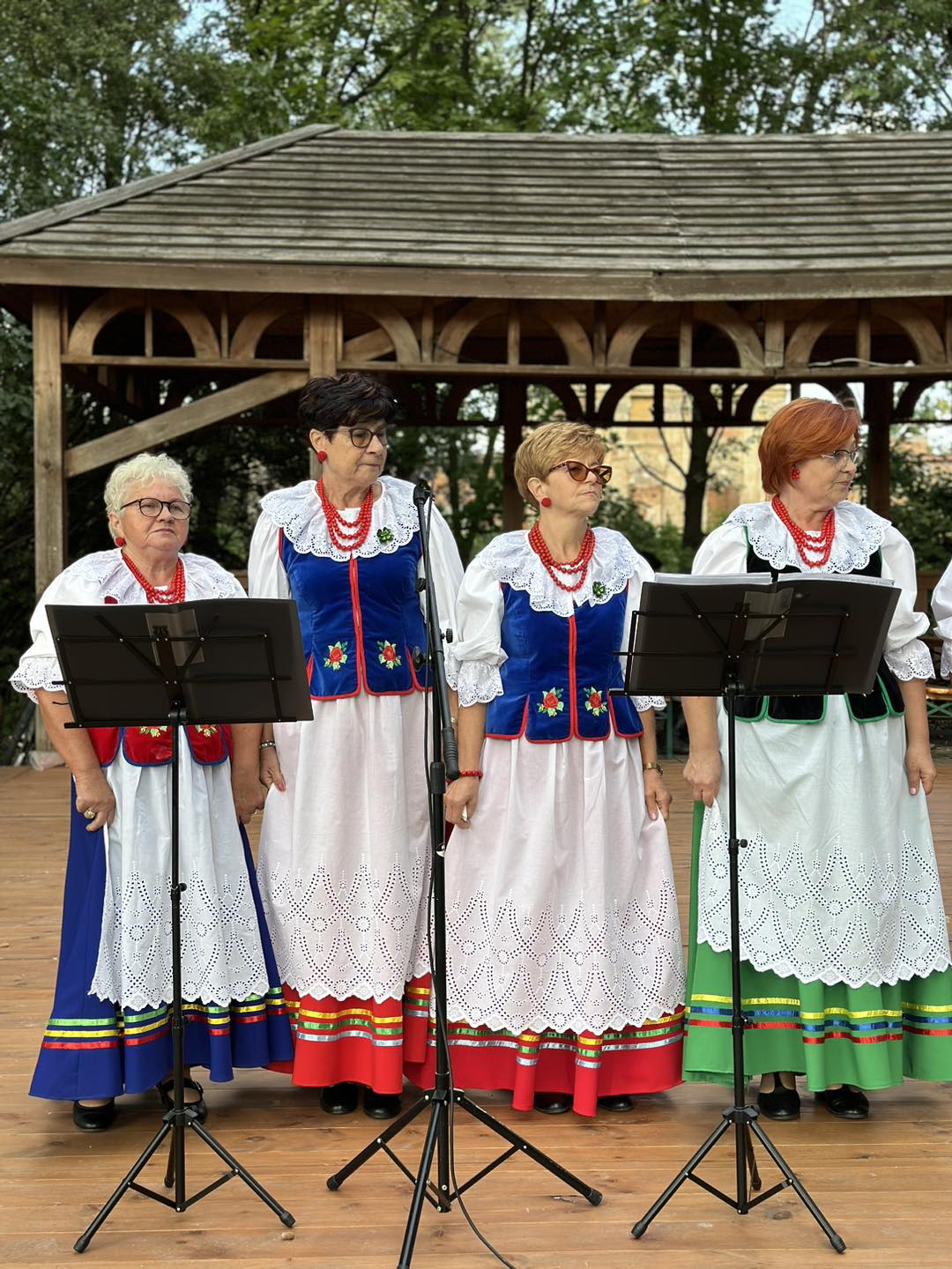 Na zdjęciu widzimy 4 śpiewające kobiety z zespołu ludowego podczas występu.
