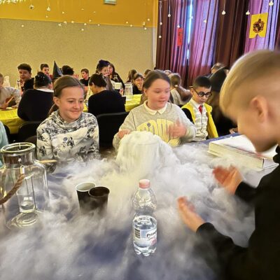 Grupa dzieci podczas warsztatów, eksperymentów chemicznych.