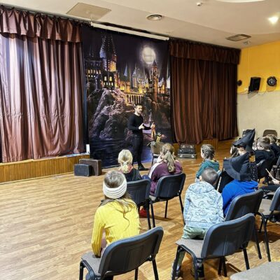 Dzieci biorące udział w warsztatach z żywymi sowami.