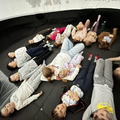 Uczestnicy kina sferycznego leżący w środku kopuły.