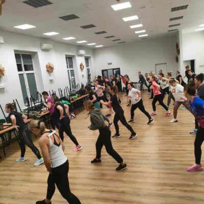 Liczna grupa kobiet na zajęciach fitness.
