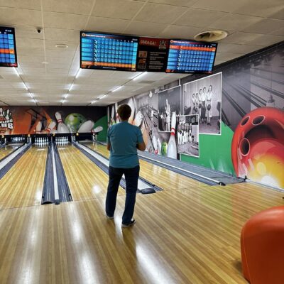 Zawodnik trzyma kule do bowlingu. Przygotowuje się do gry.