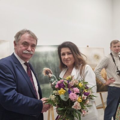 Wójt wręcza kwiaty Barbarze Różyckiej, autorce wystawy fotograficznej, towarzyszącej otwarciu świetlicy