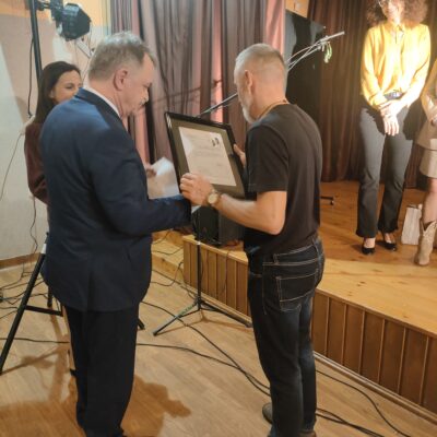 Wójt wręcza podziękowanie za udział w przeglądzie, reżyserowi TEATRU WIECZOROWĄ PORĄ