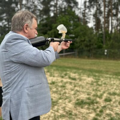 Wójt podczas oddawania strzału z painball