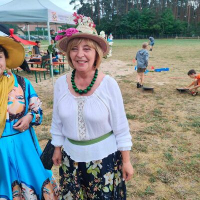 Uczestniczka konkursu w kapeluszu z żywymi kwiatami.