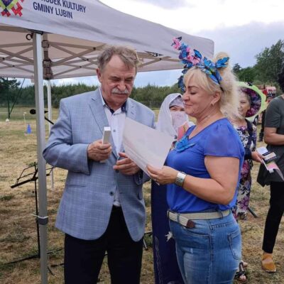 Wójt wręcza nagrode za nakrycie głowy.