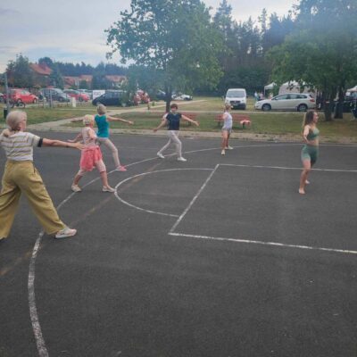 Zajęcia z jogi na boisku sportowym.