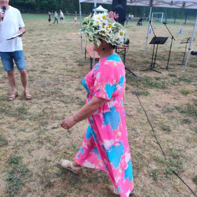 Seniorka w piękny kapeluszu z żywymi stokrotkami.