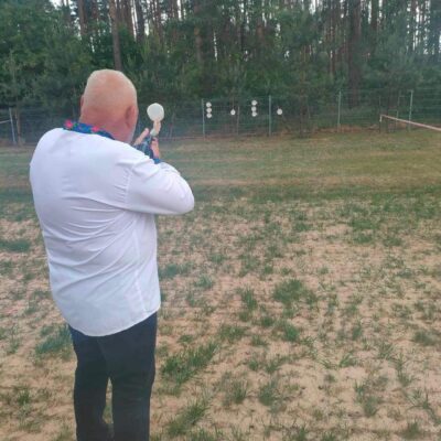 Senior strzela z painball do celu.