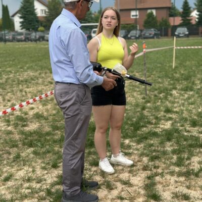 Instruktorka tłumaczy seniorowi zasady strzału baintball