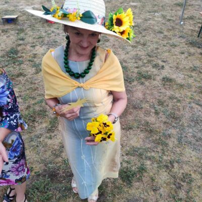 Kapelusz w słoneczniki prezentująca go seniorka