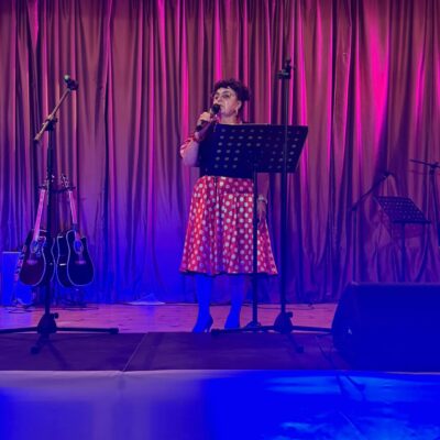 Kobieta śpiewa do mikrofonu na scenie