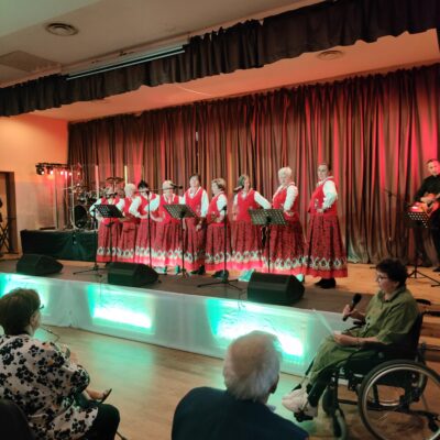 Zespół na scenie w kolorowych strojach ludowych