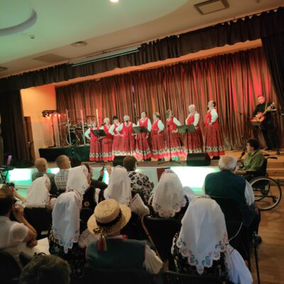 Zespół na scenie w kolorowych strojach ludowych