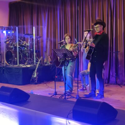 Młodzież na scenie podczas występu grają na gitarze