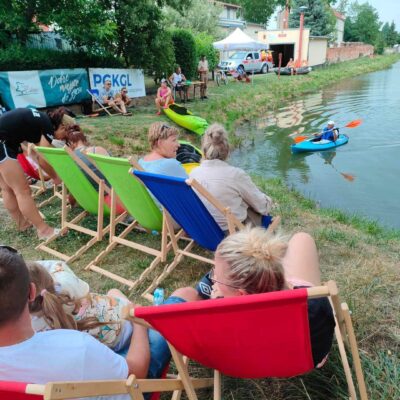 Kibice siedzą na leżakach i kibicują zawodnikom .