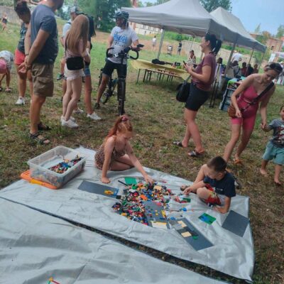 Dzieci na świeżym powietrzu układają lego.