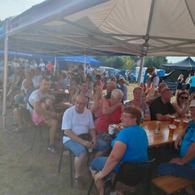 Uczestnicy siedzą pod namiotami.