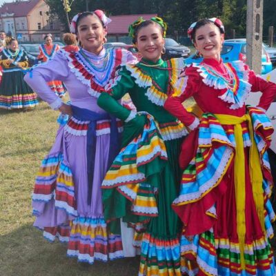 Trzy kobiety w strojach pozują do zdjęcia.