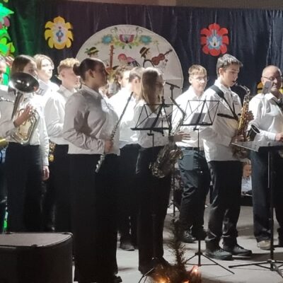 Młodzieżowa Orkiestra Dęta Gminy Lubin na scenie podczas koncertu.