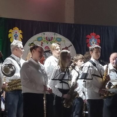 Młodzieżowa Orkiestra Dęta Gminy Lubin na scenie podczas koncertu.