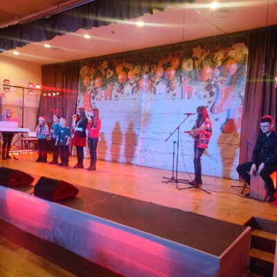 Dziecięcy Zespół wokalny. Cztery dziewczynki i jeden chłopczyk w świątecznych strojach na scenie.