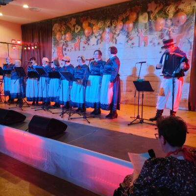 Zespół Zacheta z Zimnej Wody podczas wystepu. W niebiesko białych sukniach.