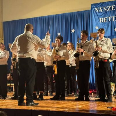 Młodzieżowa Orkiestra Dęta Gminy Lubin na scenie podczas koncertu.