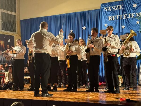 Młodzieżowa Orkiestra Dęta Gminy Lubin na scenie podczas koncertu.