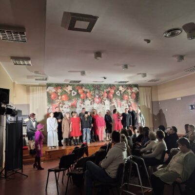 Artyści z teatru Zwykli Ludzie na scenie po spektaklu. Publiczność oklaskuje artystów.