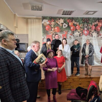 Wójt Tadeusz Kielan wraz z Radnym Norbertem Grabowskim wręczają podziękowanie Pani Teresie Kot za występ.