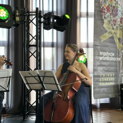 Artystka na scenie siedzi i gra na wiolonczeli