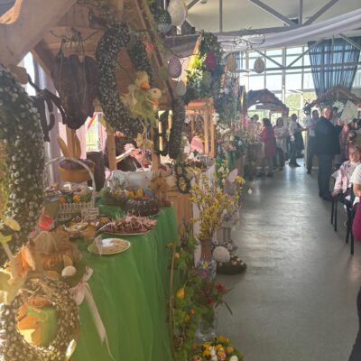 Domki kół udekorowane wiosennie , Jajka wianki, kwiaty.