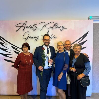 Chór pozuje na ściance do zdjęć razem z dyrygentem Wojciechem Banachem