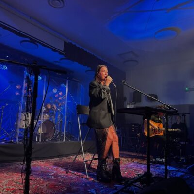 Artystka Kasia Kowalska na scenie siedzi i śpiewa.