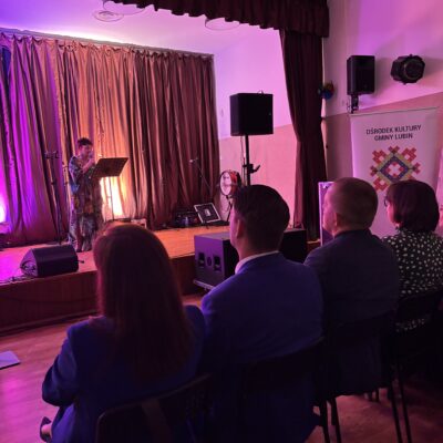 Kobieta śpiewa sama na scenie. światła w tle.