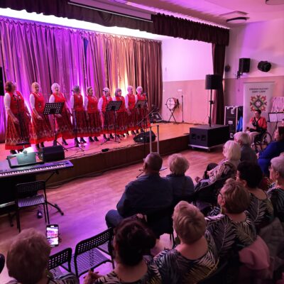 Zespół na scenie w czerwonych folkowych strajach.