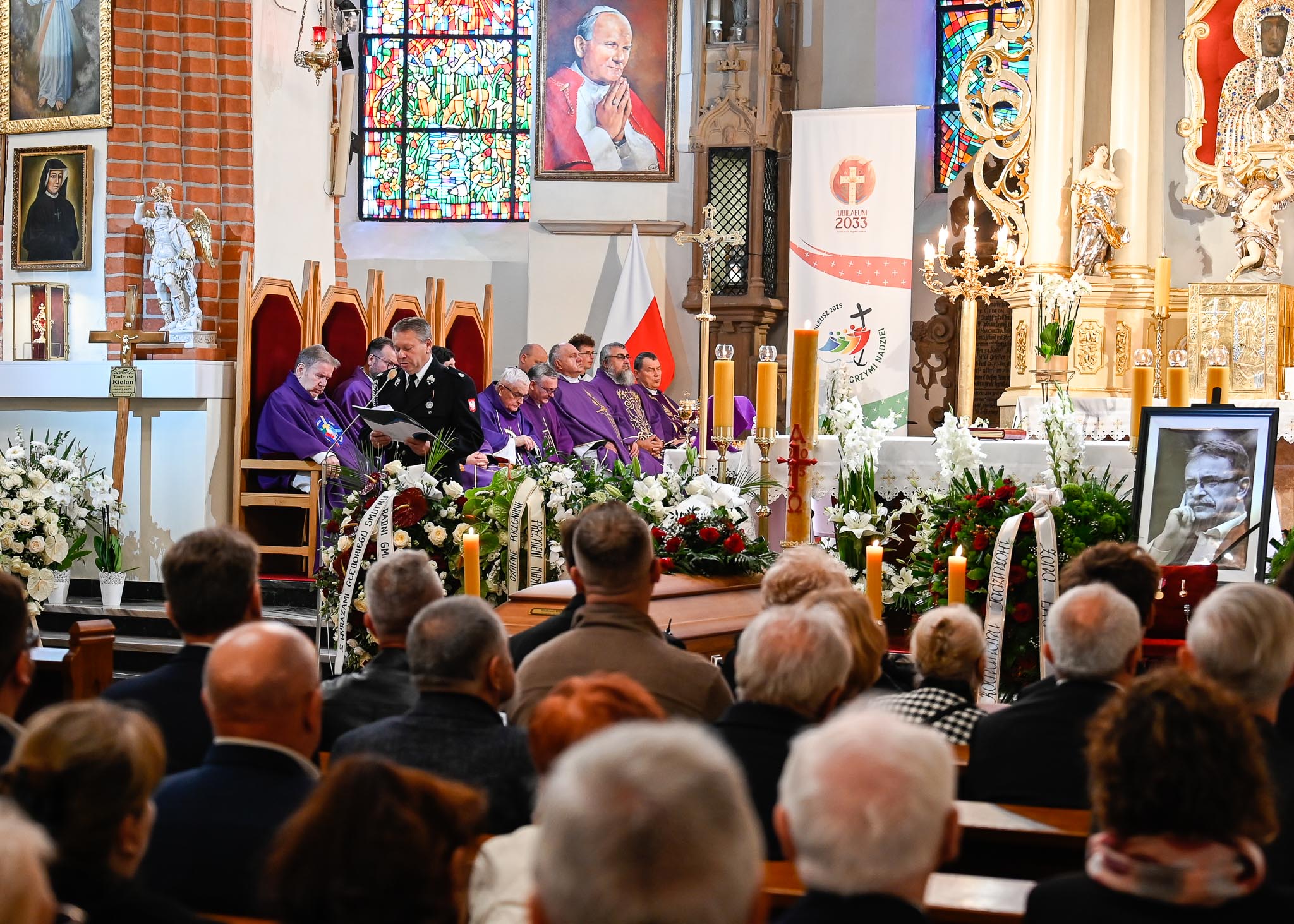 Ceremonia pogrzebowa, ludzie siedzący w ławkach.